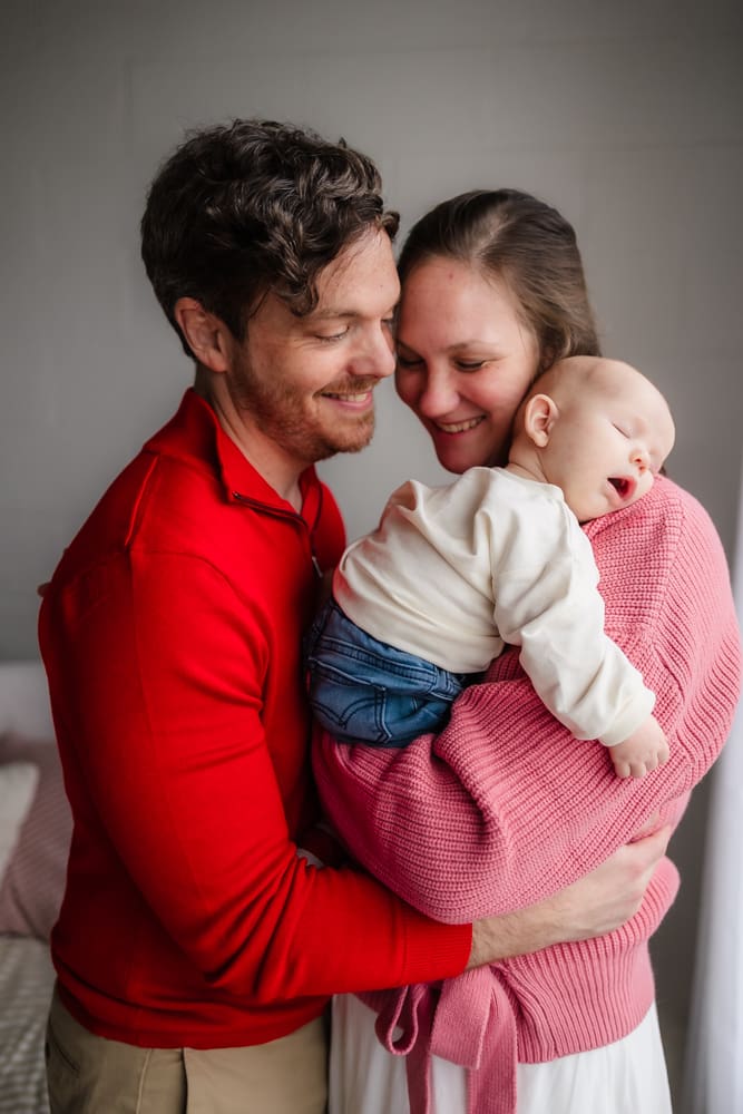 mom and dad snuggling together during valentine's themed 3 month milestone photography session in knoxville tn