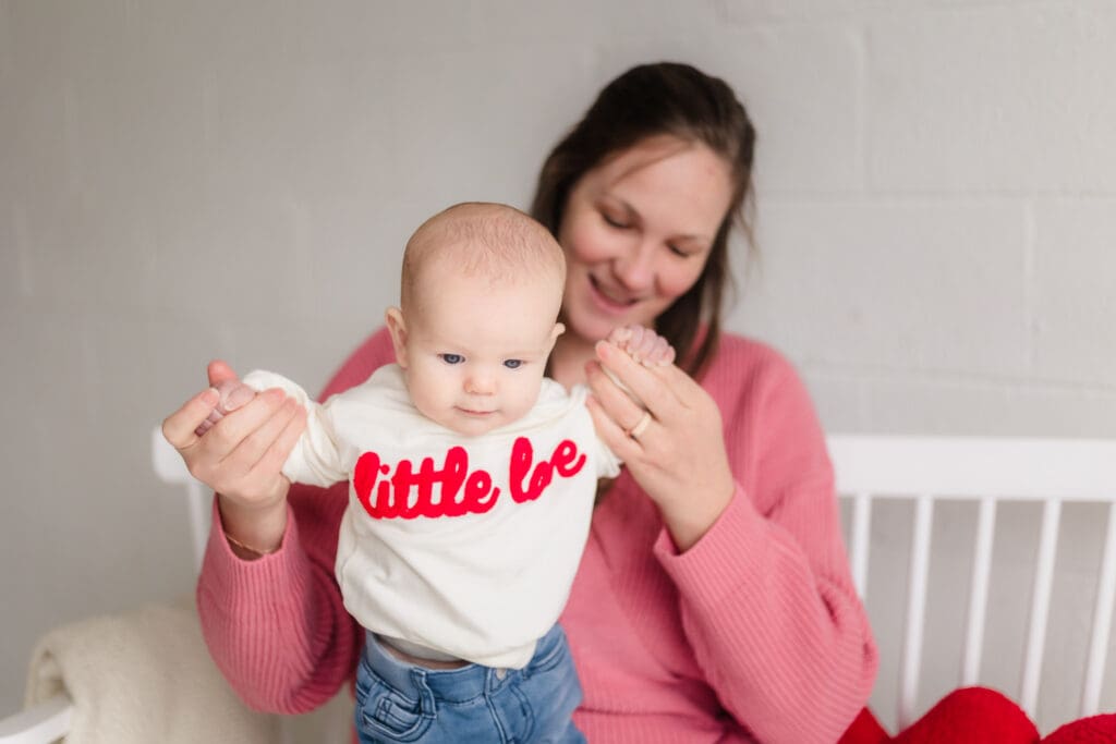 mom helping baby stand during valentine's themed 3 month milestone photography session in knoxville tn