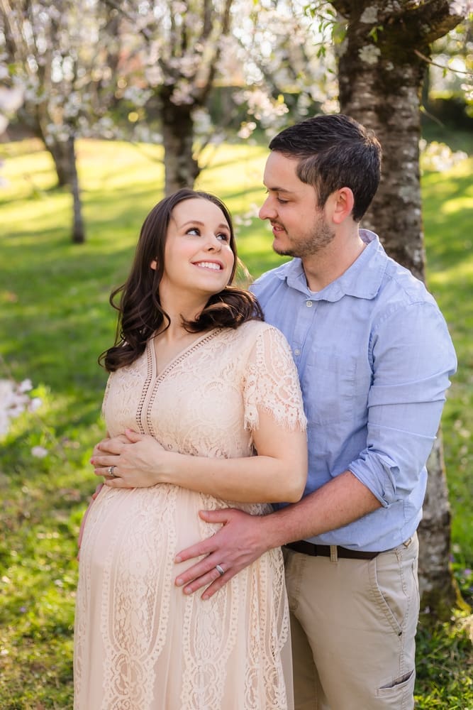 mom and dad smiling at each other during maternity photography session in knoxville tn