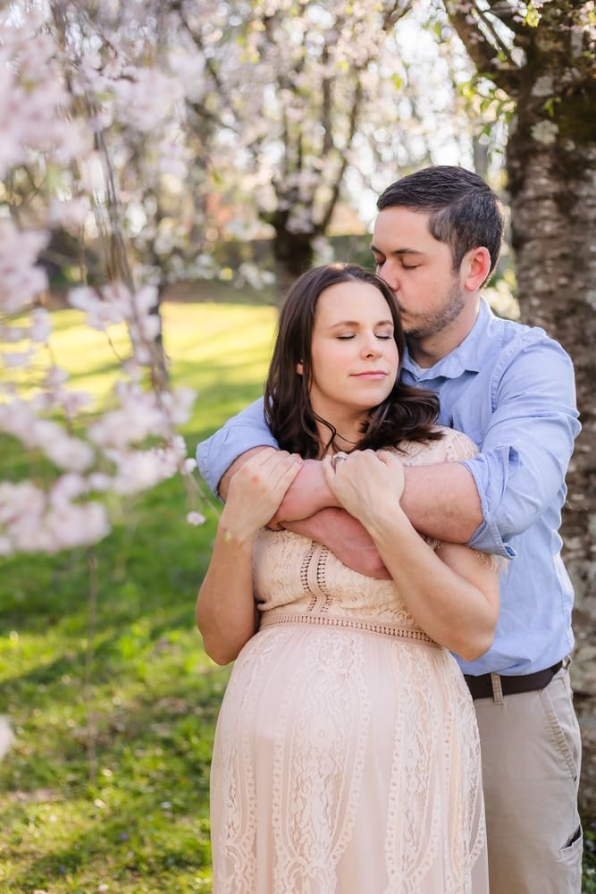mom and dad snuggling during maternity photography session in knoxville tn