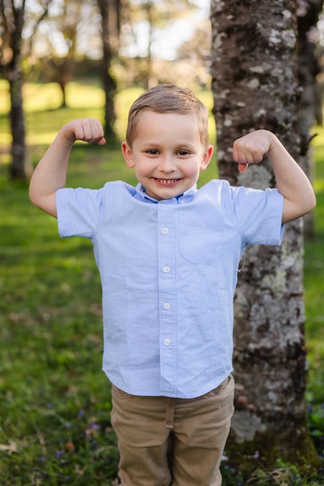 son doing muscle arms during maternity photography session in knoxville tn