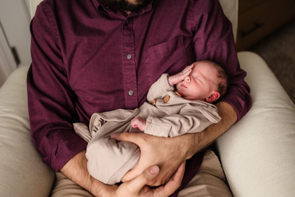 dad holding newborn during in home lifestyle newborn photography session in knoxville tn