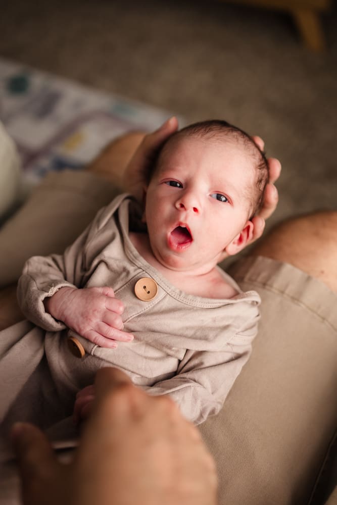 newborn starting to yawn during in home lifestyle newborn photography session in knoxville tn