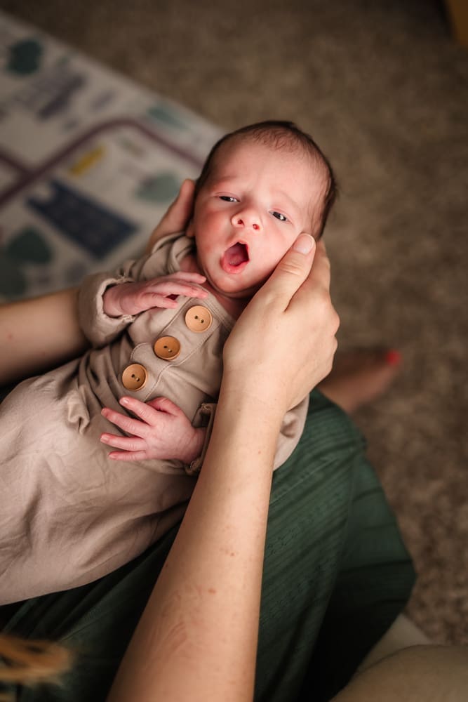 newborn baby boy yawning during in home lifestyle newborn photography session in knoxville tn