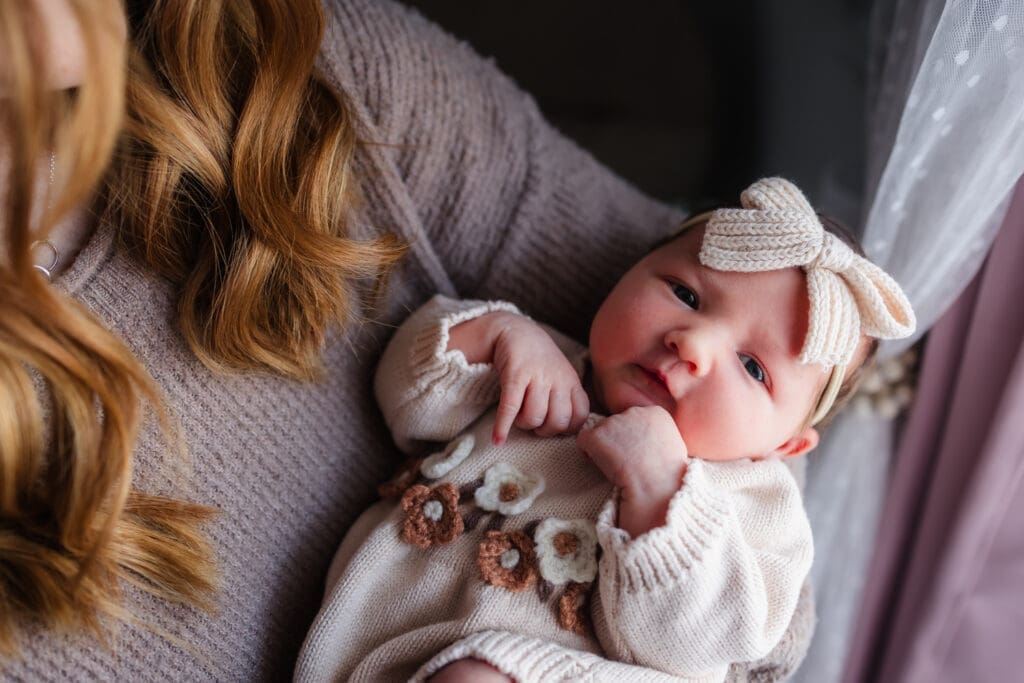 newborn in moms arms during in-home lifestyle newborn session by knoxville newborn and maternity photographer Kelsey Wood Portraits.