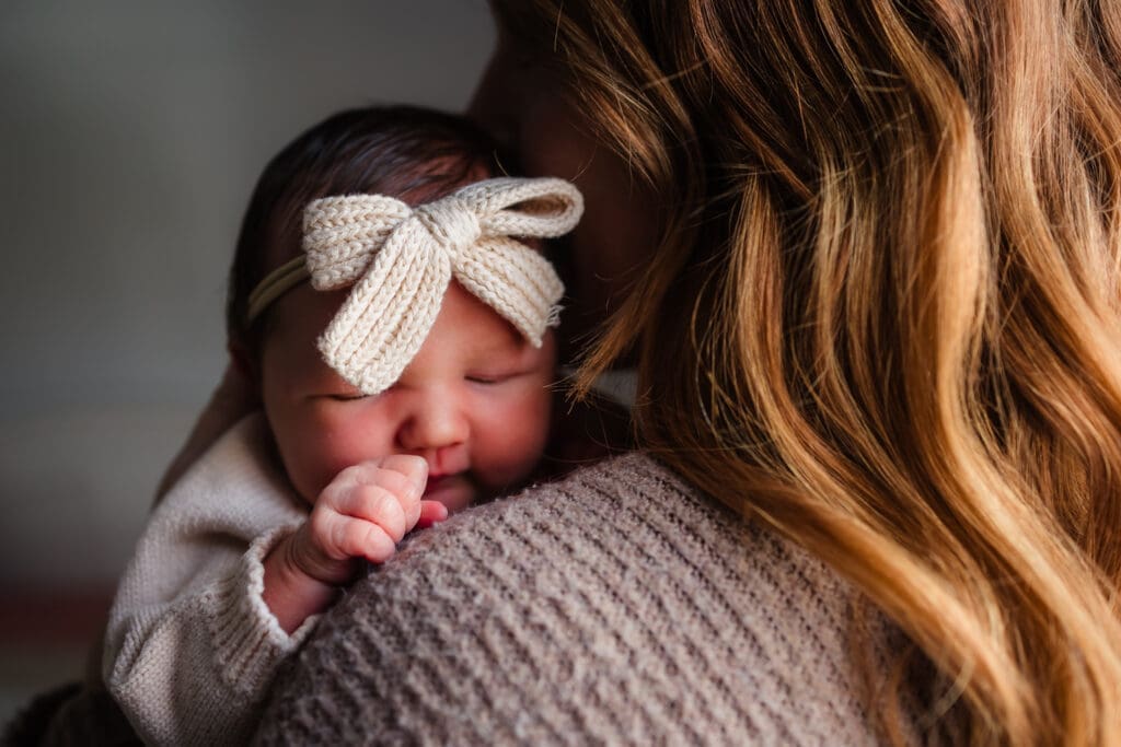 newborn on moms shoulder during in-home lifestyle newborn session by knoxville newborn and maternity photographer Kelsey Wood Portraits.