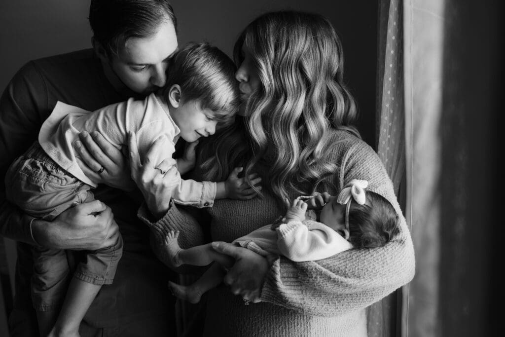 black and white of family with newborn during in-home lifestyle newborn session by knoxville newborn and maternity photographer Kelsey Wood Portraits.