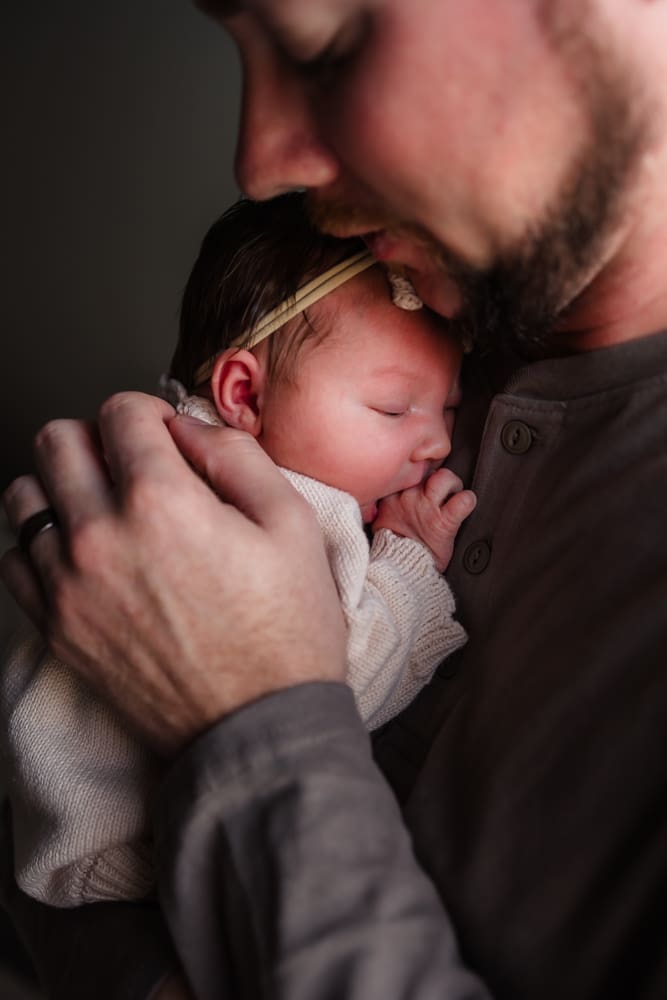 dad snuggling newborn during in-home lifestyle newborn session by knoxville newborn and maternity photographer Kelsey Wood Portraits.