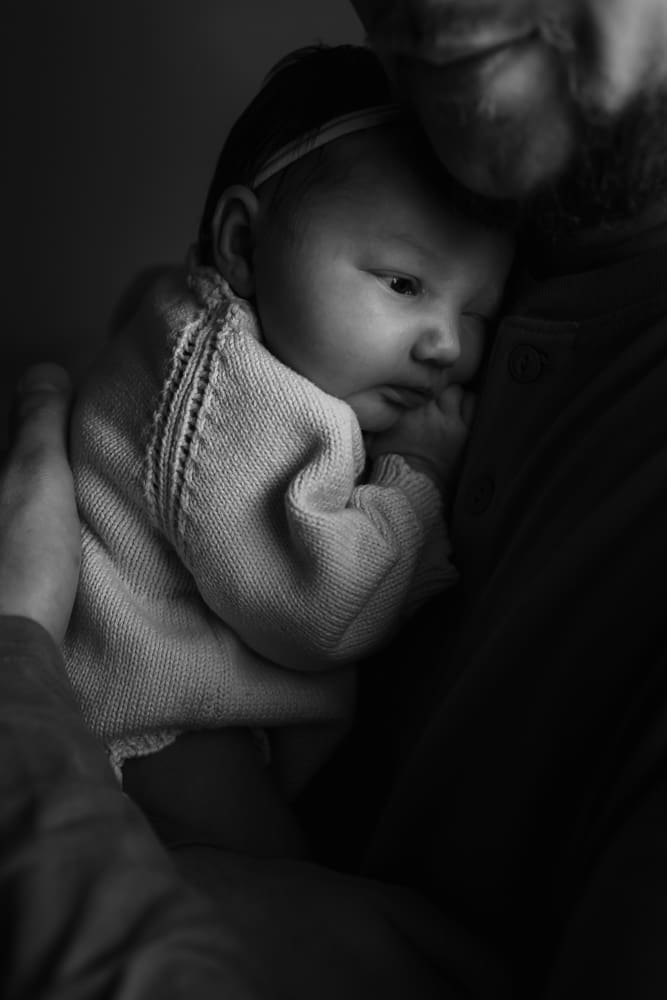 black and white photo of newborn chilling on dads chest during in-home lifestyle newborn session by knoxville newborn and maternity photographer Kelsey Wood Portraits.