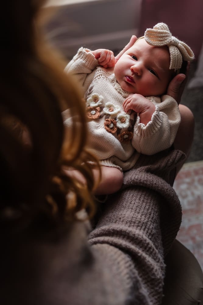 newborn on moms lap during in-home lifestyle newborn session by knoxville newborn and maternity photographer Kelsey Wood Portraits.