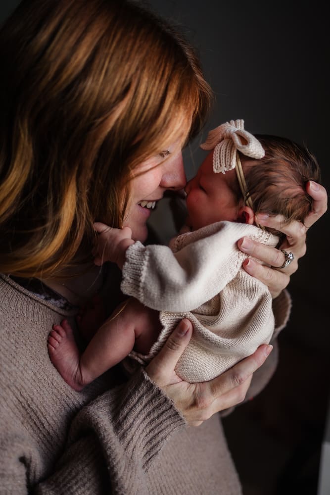 mom nose to nose with newborn during in-home lifestyle newborn session by knoxville newborn and maternity photographer Kelsey Wood Portraits.