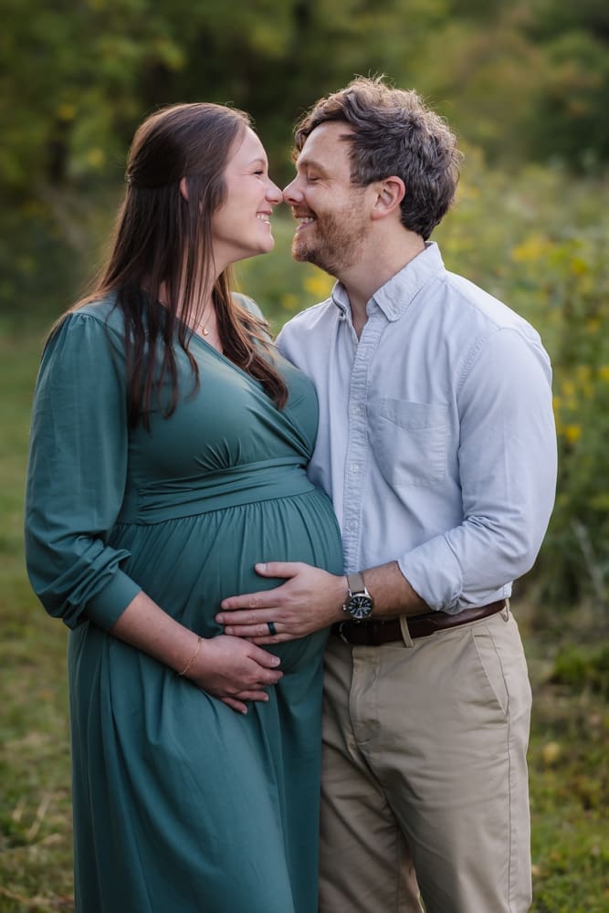 mom and dad nuzzle together during knoxville maternity photo shoot at seven isalnds park in kodak