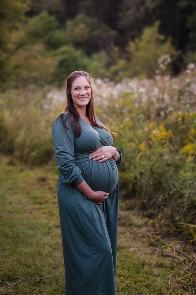 expecting mama in a field during knoxville maternity photo shoot at seven isalnds park in kodak