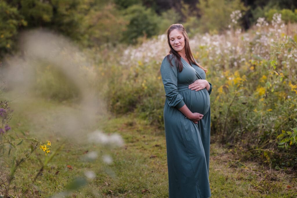 expecting mom holding baby bump during knoxville maternity photo shoot at seven isalnds park in kodak