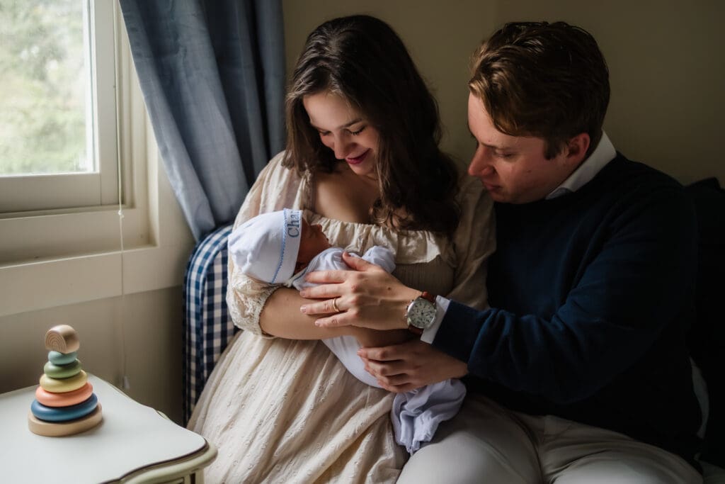 mom and dad holding baby close during in-home lifestyle newborn photography session in knoxville tn