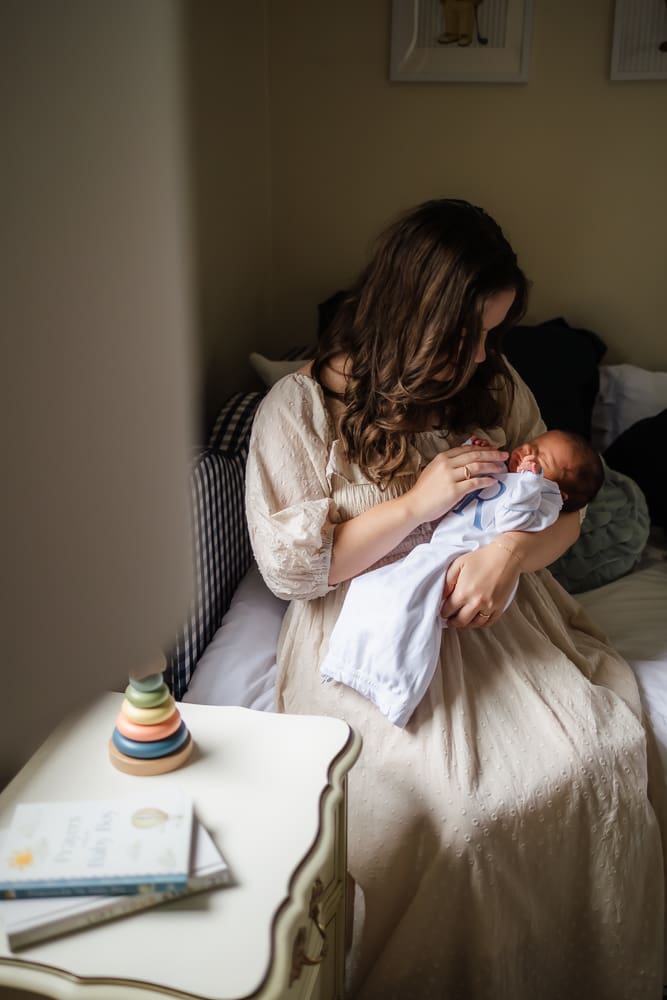 mom holding newborn during in-home lifestyle newborn photography session in knoxville tn