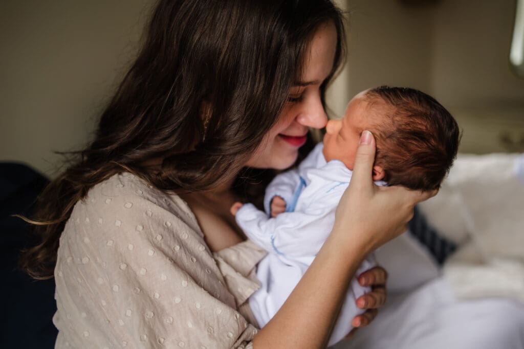 mom nose to nose with baby during in-home lifestyle newborn photography session in knoxville tn