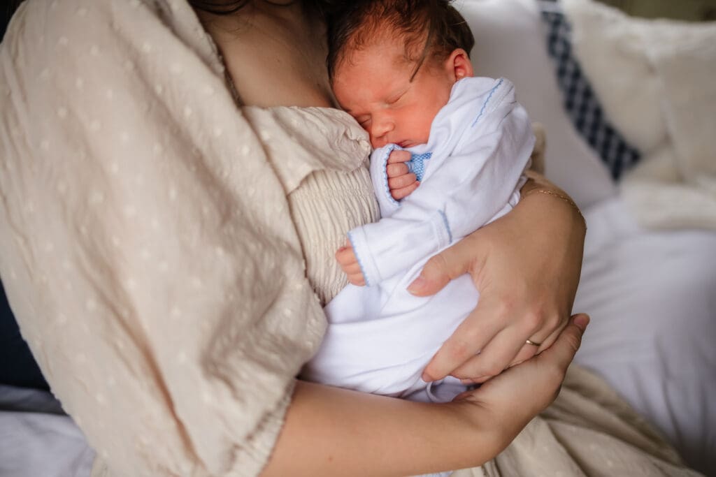 mom snuggling baby during in-home lifestyle newborn photography session in knoxville tn