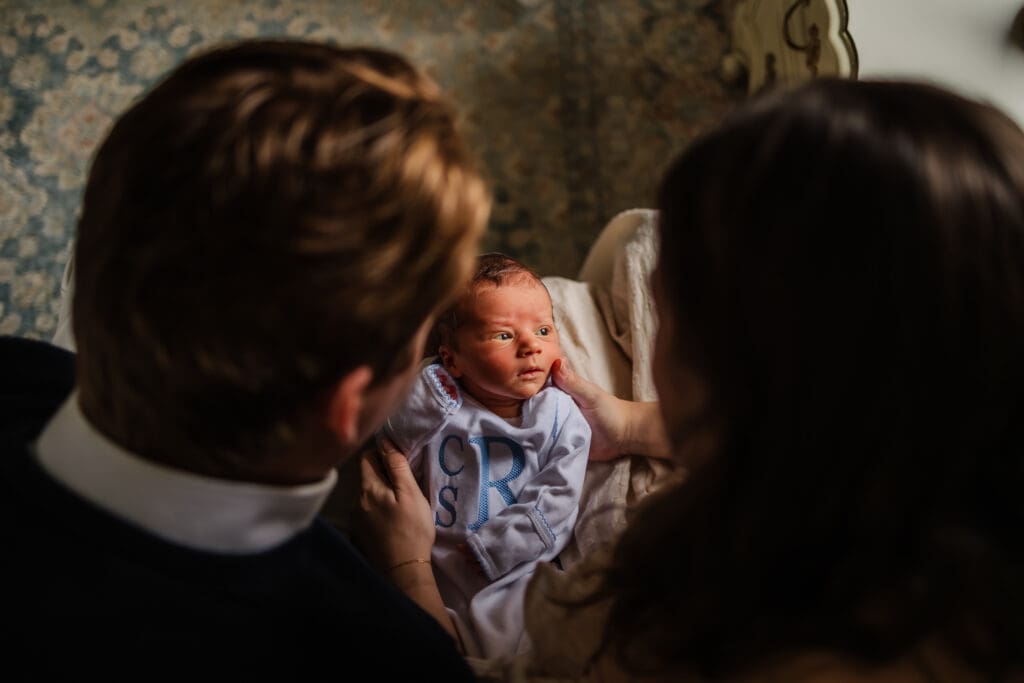 baby looking out window during in-home lifestyle newborn photography session in knoxville tn