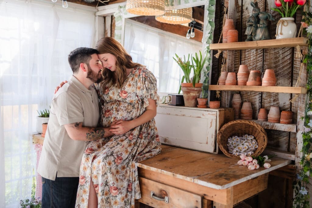 expecting parents share a moment together during knoxville maternity photography session at the Holmstead studio