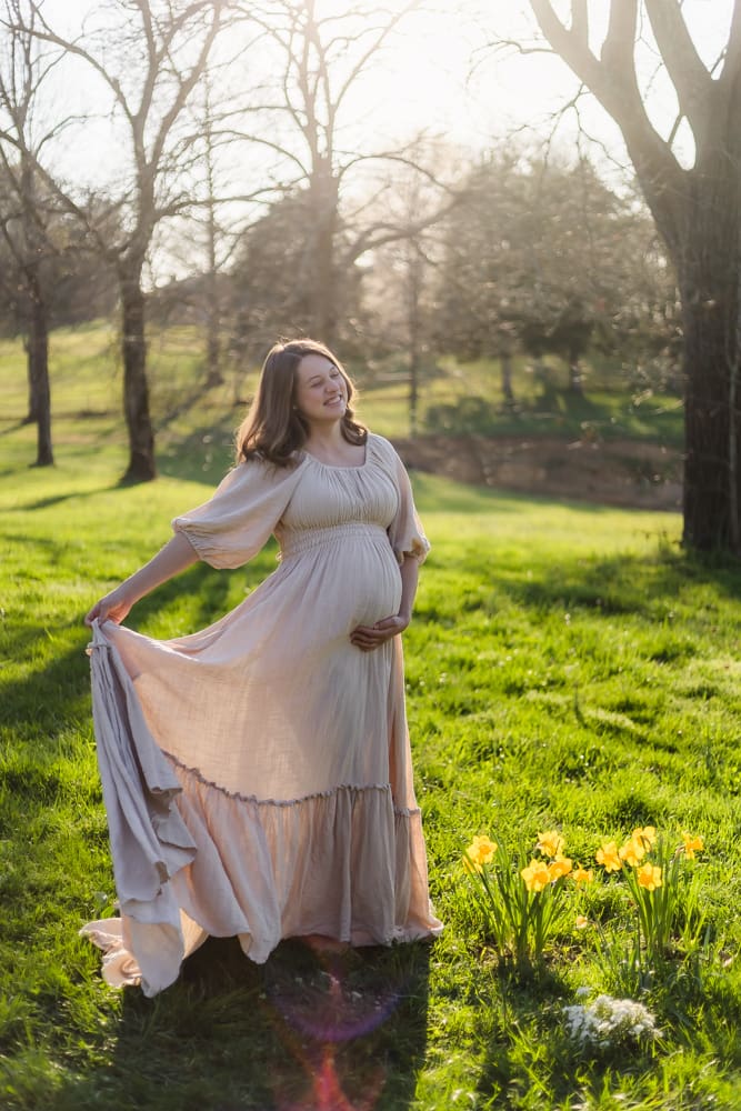 mom playing with reclamation dress during knoxville maternity photography session at the Holmstead studio