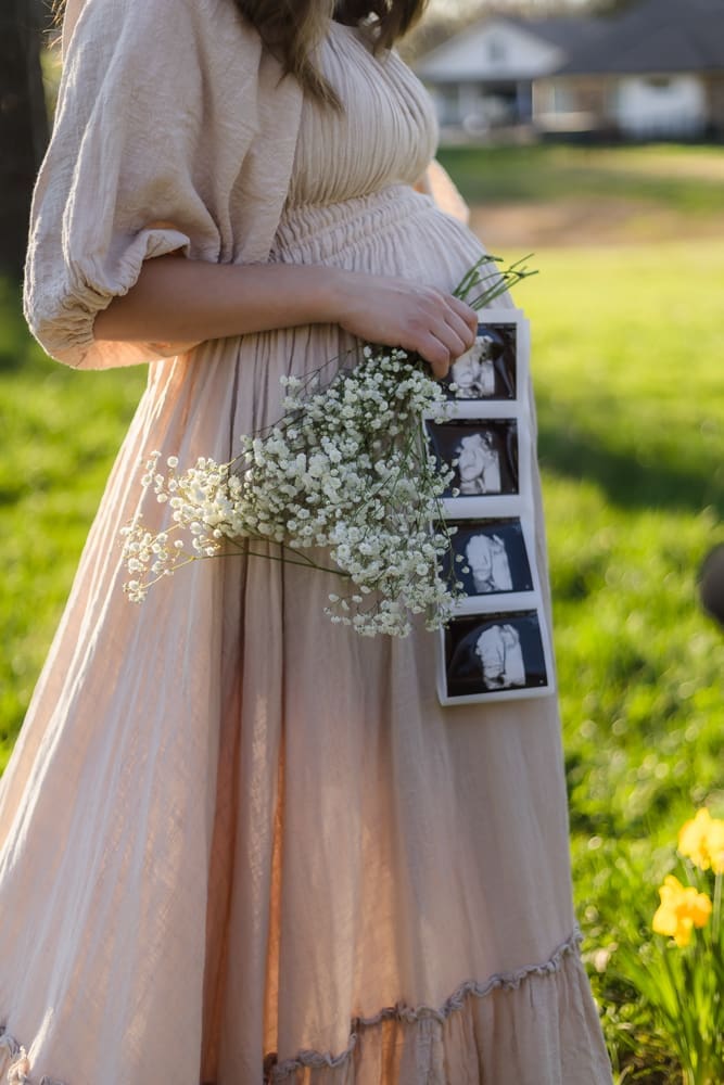 mom holding baby ultrasound and babys breath during knoxville maternity photography session at the Holmstead studio