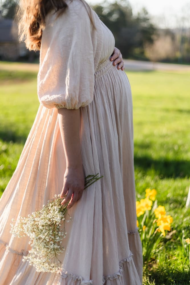 mom holding baby bump during knoxville maternity photography session at the Holmstead studio