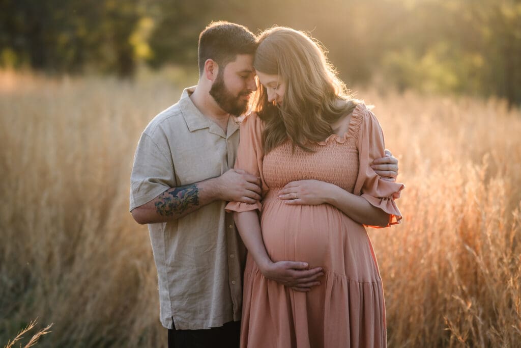mom and dad snuggle together during knoxville maternity photography session at the Holmstead studio