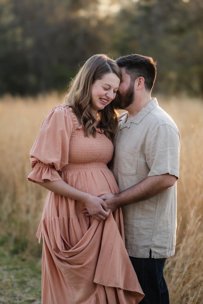 mom and dad snuggling together sharing a moment during knoxville maternity photography session at the Holmstead studio