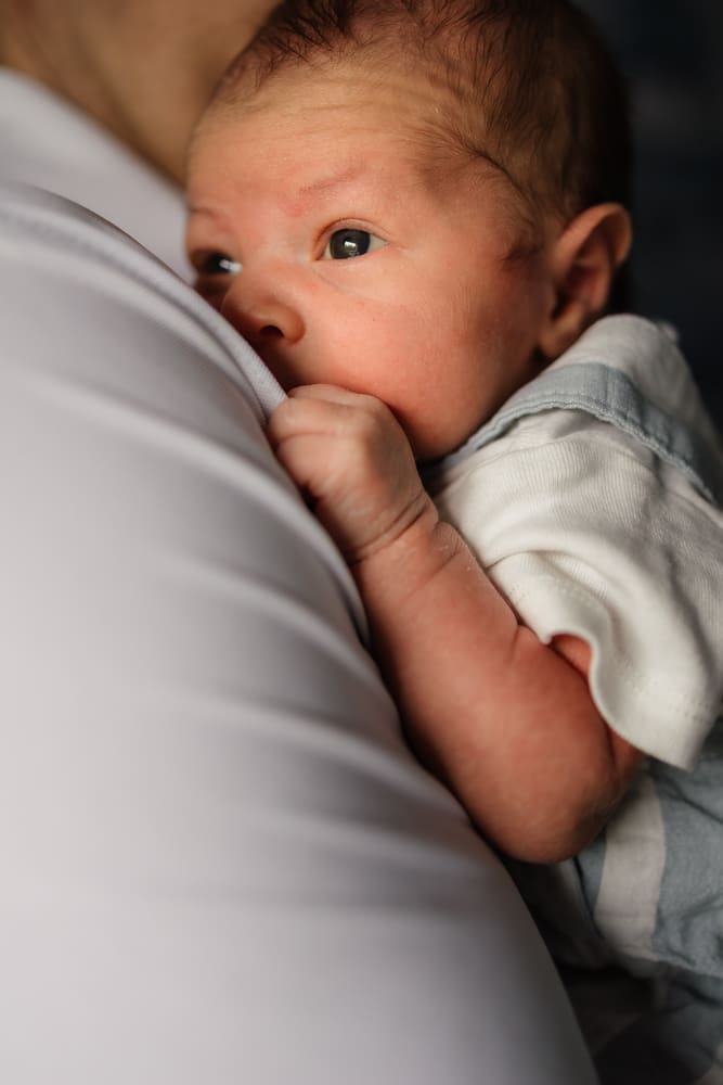 newborn baby boy looking over dad's shoulder during knoxville in-home lifestyle newborn photography session