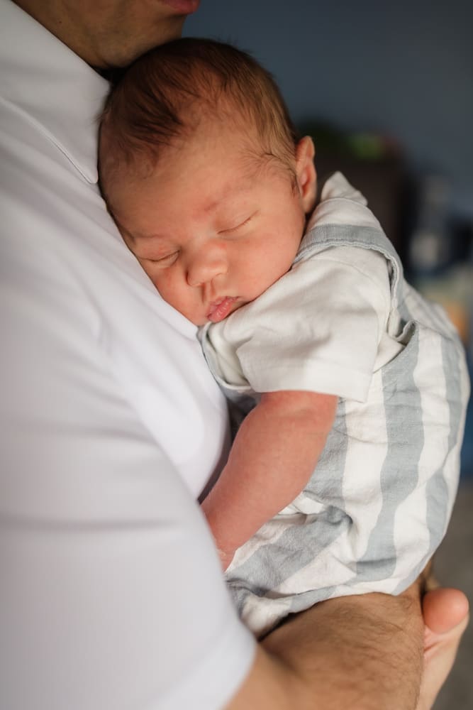 newborn baby boy asleep on dad's chest during knoxville in-home lifestyle newborn photography session