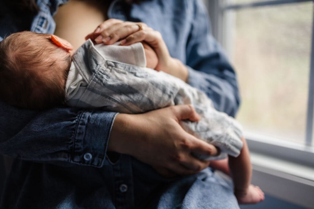 mom nursing baby during knoxville in-home lifestyle newborn photography session