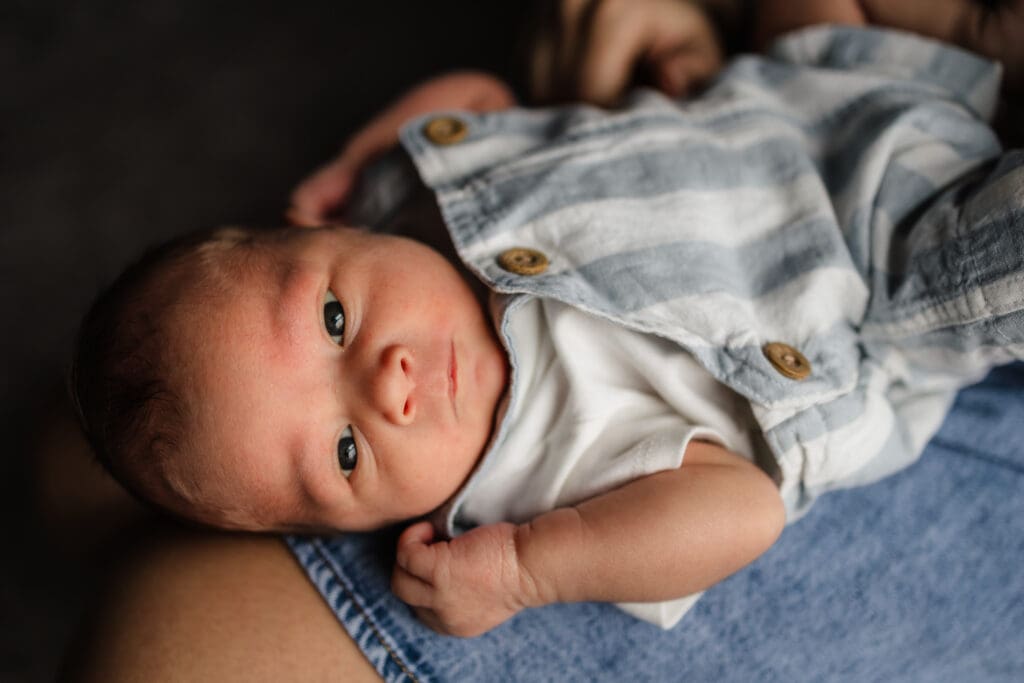 baby laying on mom's lap during knoxville in-home lifestyle newborn photography session