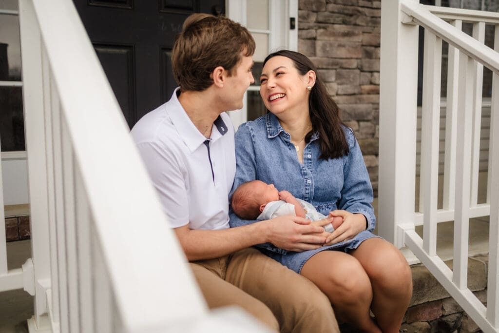 mom and dad smiling at each other during knoxville in-home lifestyle newborn photography session