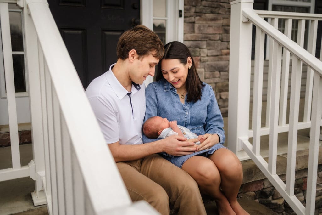 mom and dad smiling at newborn during knoxville in-home lifestyle newborn photography session