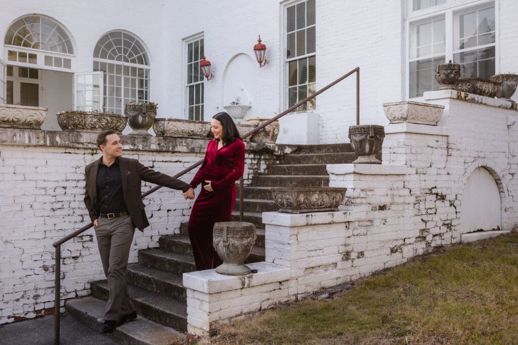 expecting couple walking down stairs during knoxville maternity session at the bleak house