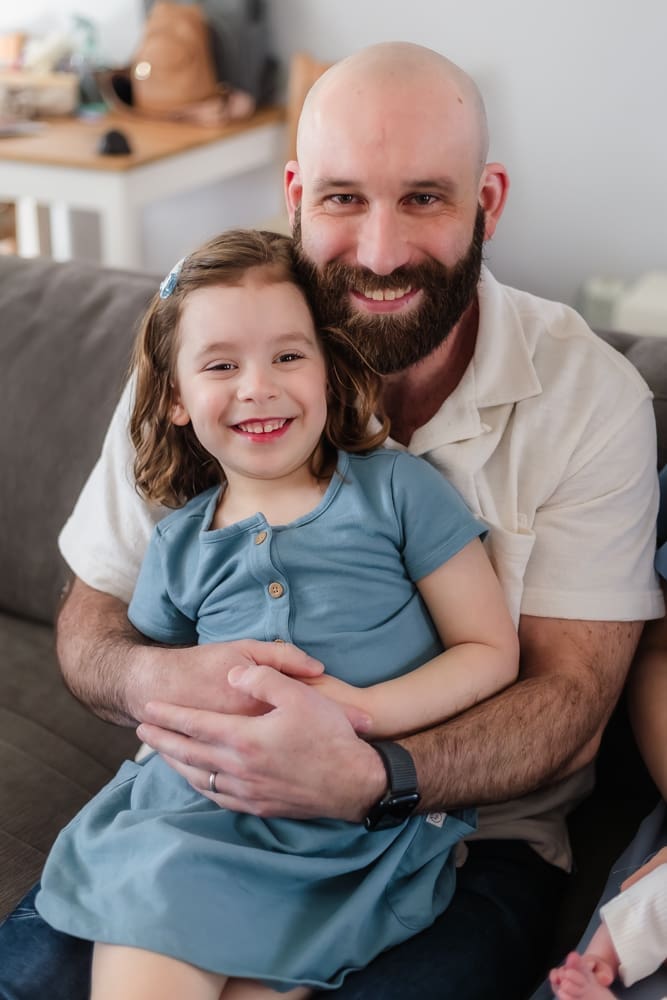 big sister and dad smiling during lifestyle newborn session
