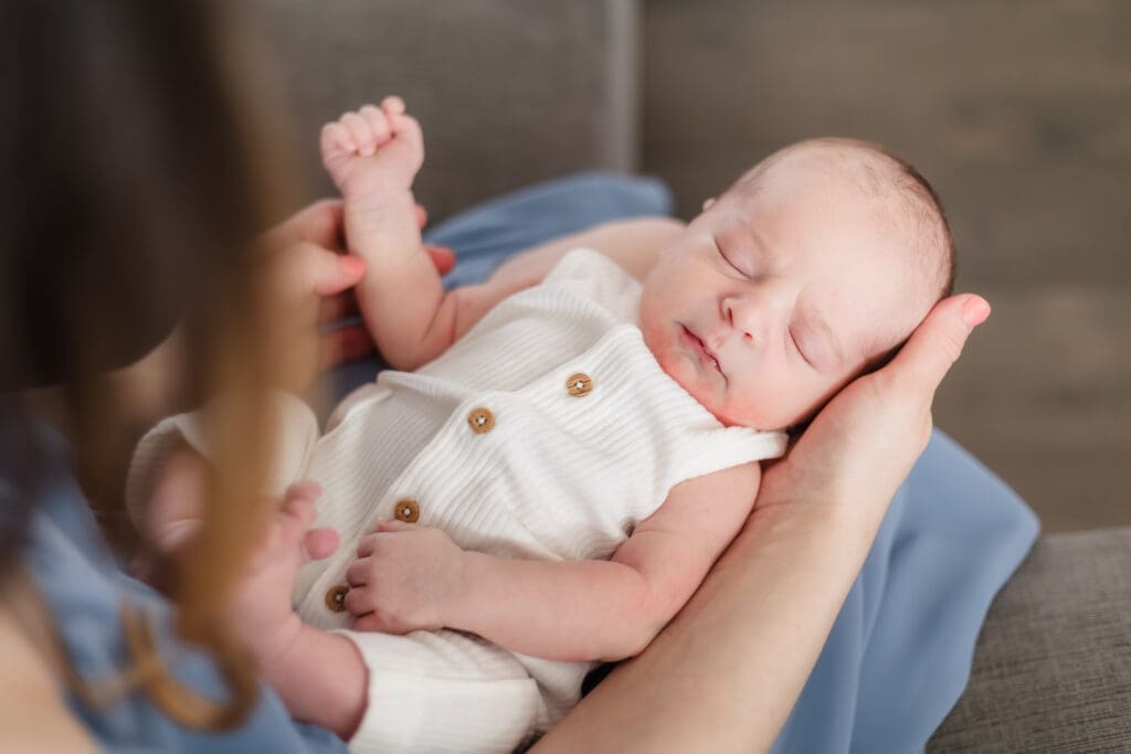 newborn laying on mom's lap during lifestyle newborn photos