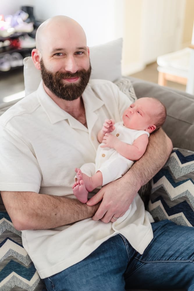 dad holding newborn during newborn photos