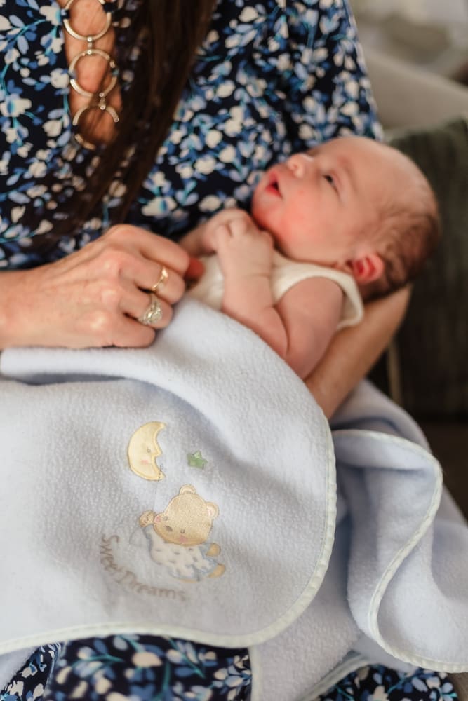 detail of baby blanket passed down from dad to newborn during newborn session