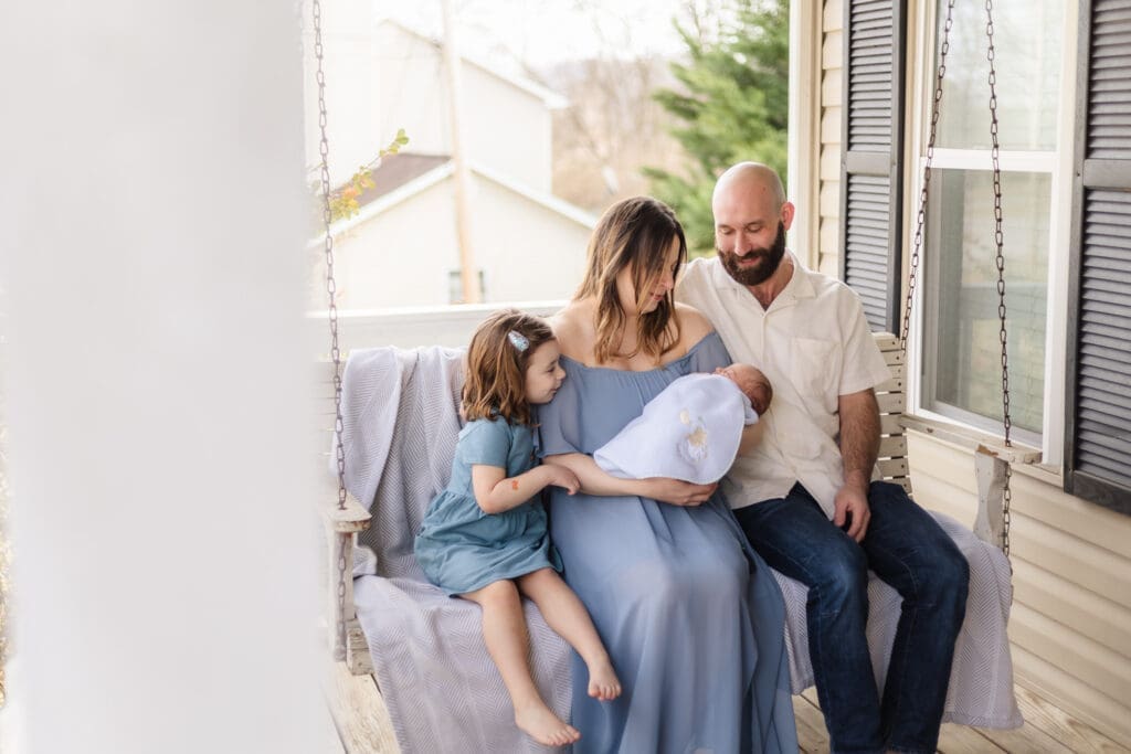 family swinging on front porch during knoxville newborn session