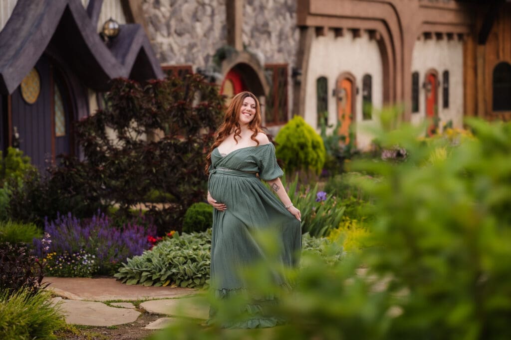 mom playing with dress during fantasy inspired knoxville maternity photography session at ancient lore village