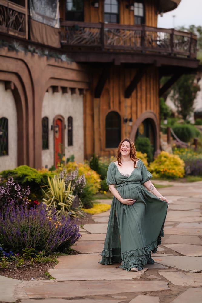 mom walking in front of hobbit village during fantasy inspired knoxville maternity photography session at ancient lore village