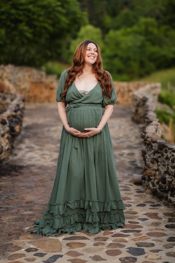 mom standing on a bridge during fantasy inspired knoxville maternity photography session at ancient lore village