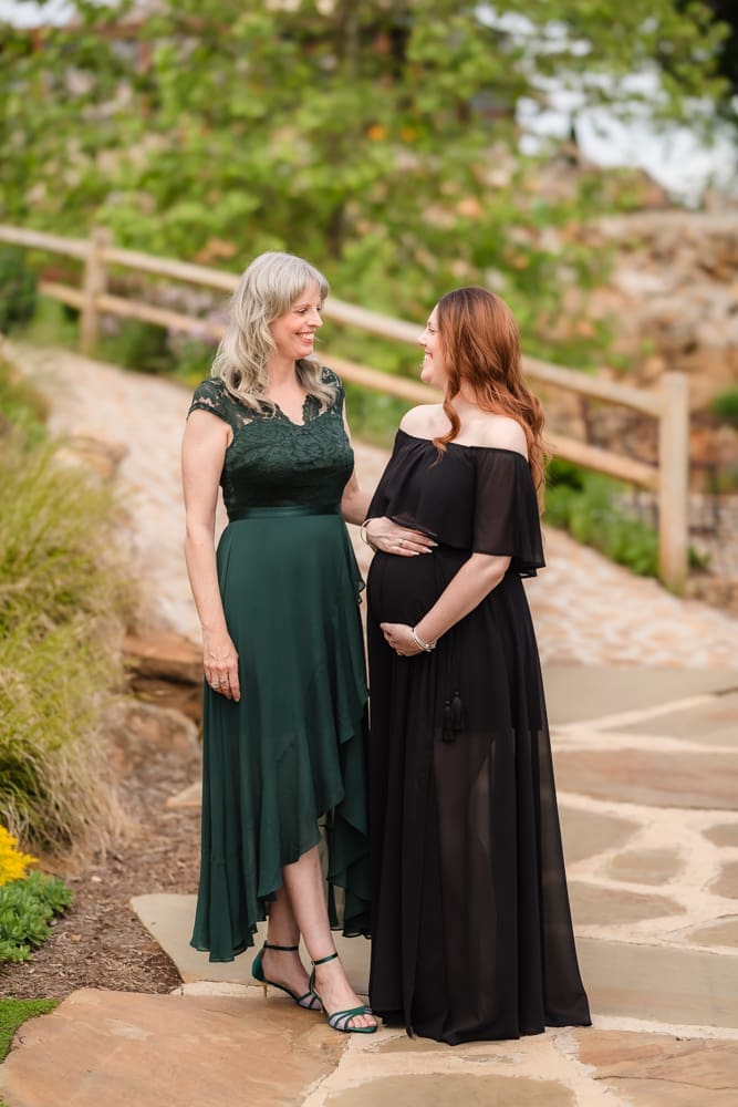 mom and grandma smiling at each other during fantasy inspired knoxville maternity photography session at ancient lore village