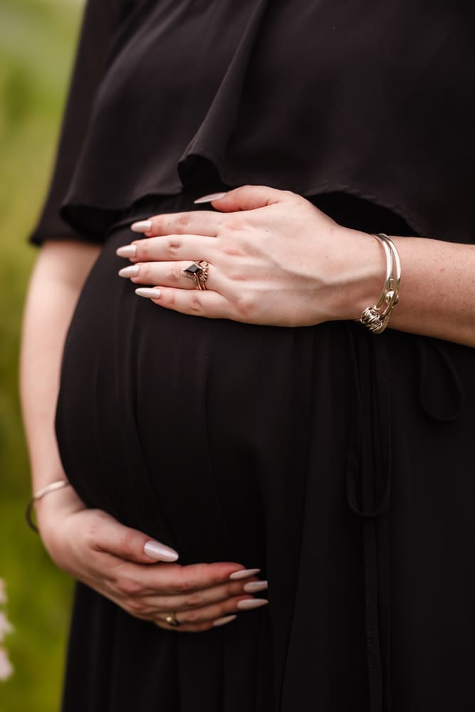 detail shot of moms baby bump and gorgeous engagement ring during fantasy inspired knoxville maternity photography session at ancient lore village