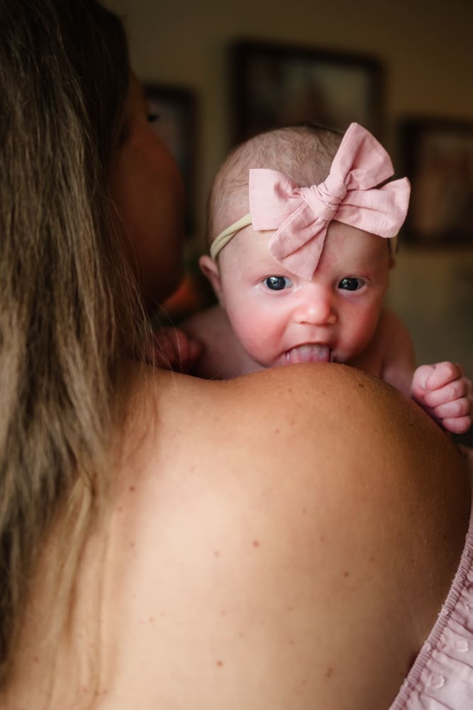 Newborn baby girl resting against her mother during a Powell TN in-home newborn session