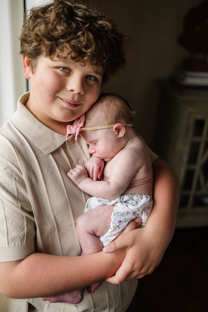 Proud big brother holding his newborn baby sister during a Powell TN lifestyle newborn session