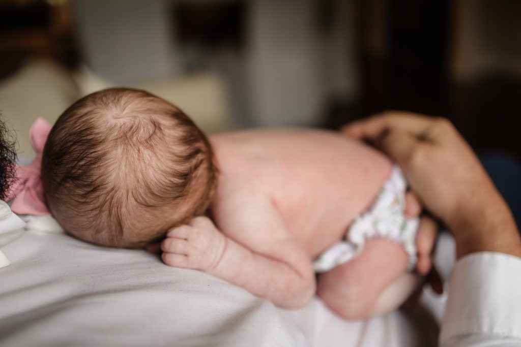close-up of newborn baby resting on her father's chest during a Powell TN in-home session